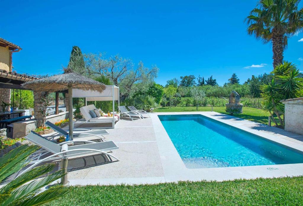 a swimming pool with chairs and a gazebo at Villa Antonia in El Port