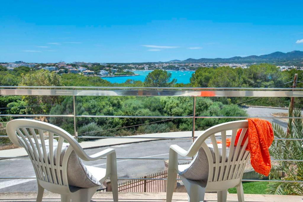 two chairs on a balcony with a view of the water at Ses Crestes in Portocolom