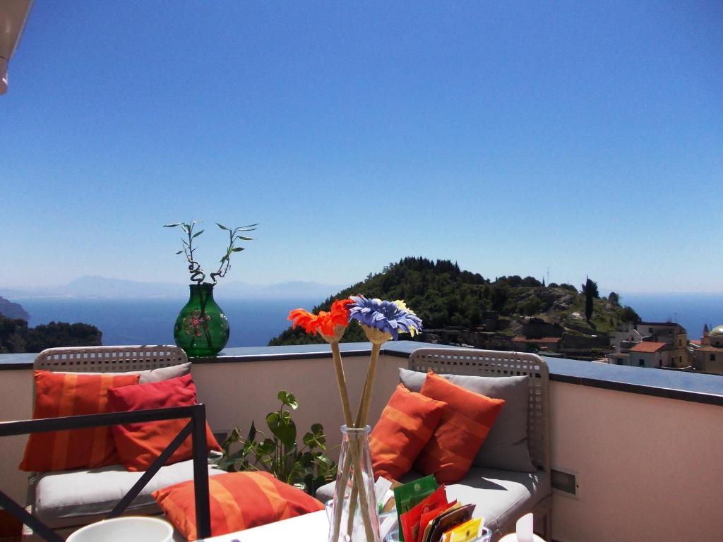 a balcony with two chairs and a table with flowers at L'Arabesco B&B in Amalfi