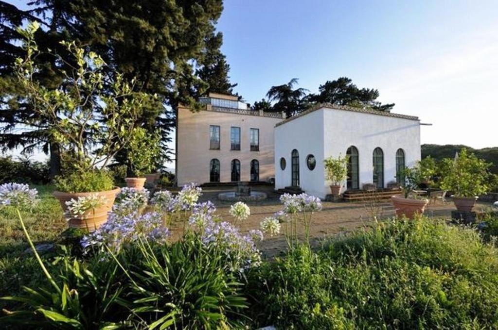 ein großes weißes Haus mit Blumen davor in der Unterkunft Pavillon Torre Del Falco in Ronciglione