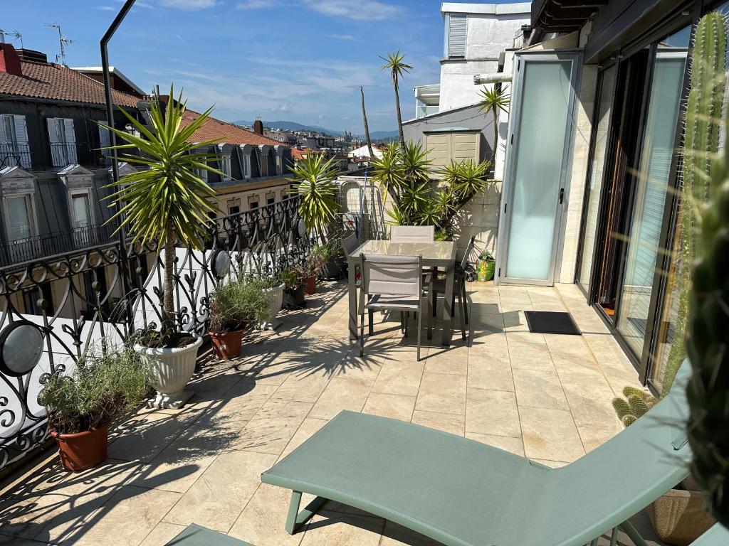 eine Terrasse mit einem Tisch und Stühlen auf dem Balkon in der Unterkunft Boulevard Apartmento in San Sebastián