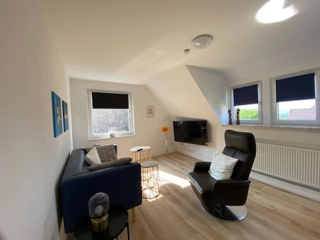 sala de estar con 2 sillas y TV en Haus Sunshine - Ferienwohnung Sunshine 1, en Hessisch Oldendorf