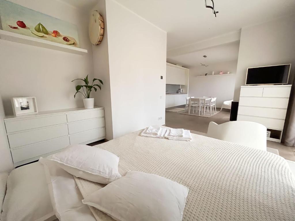 ein weißes Schlafzimmer mit einem Bett und ein Wohnzimmer in der Unterkunft Ivory House in Jūrmala