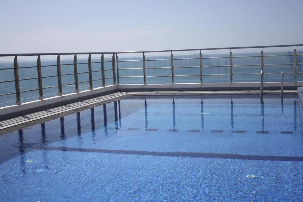 a swimming pool with blue water and a fence at Next to Indian Ocean in Colombo