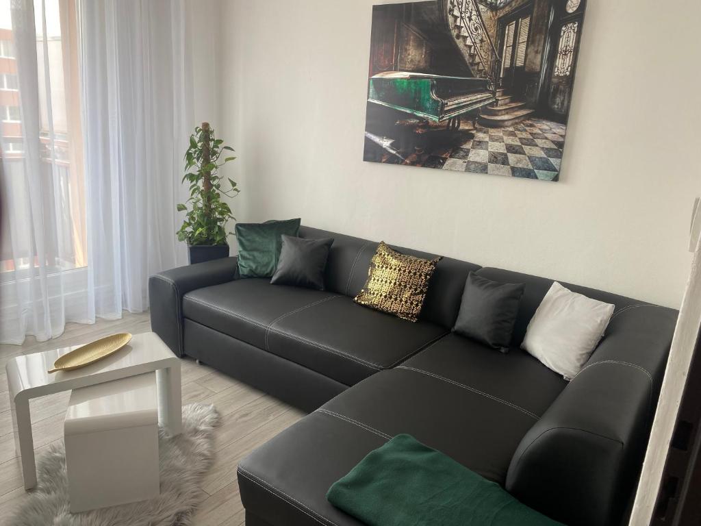 a living room with a black couch and a table at Apartmán v Třebíči in Třebíč