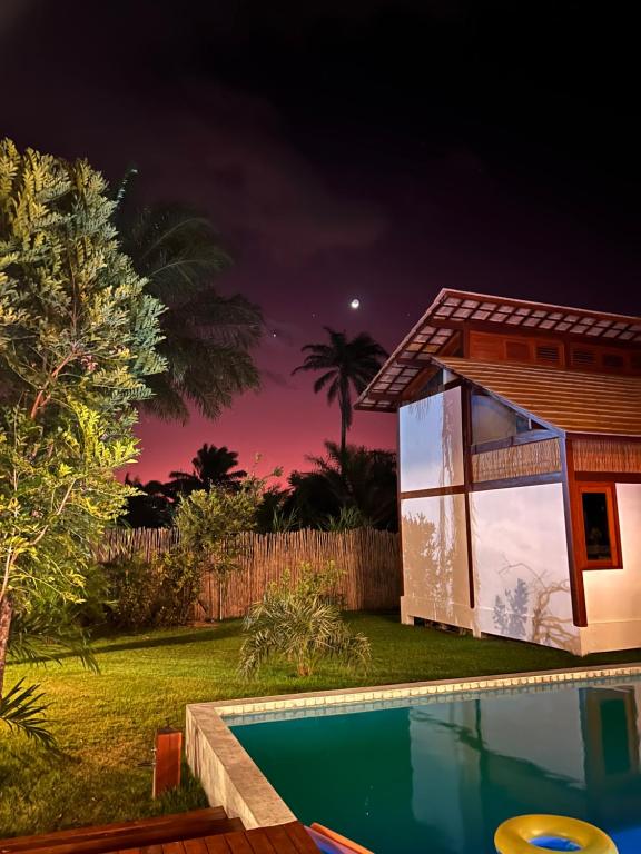 a house with a swimming pool at night at Pequena Lua Flats - Península de Maraú in Barra Grande