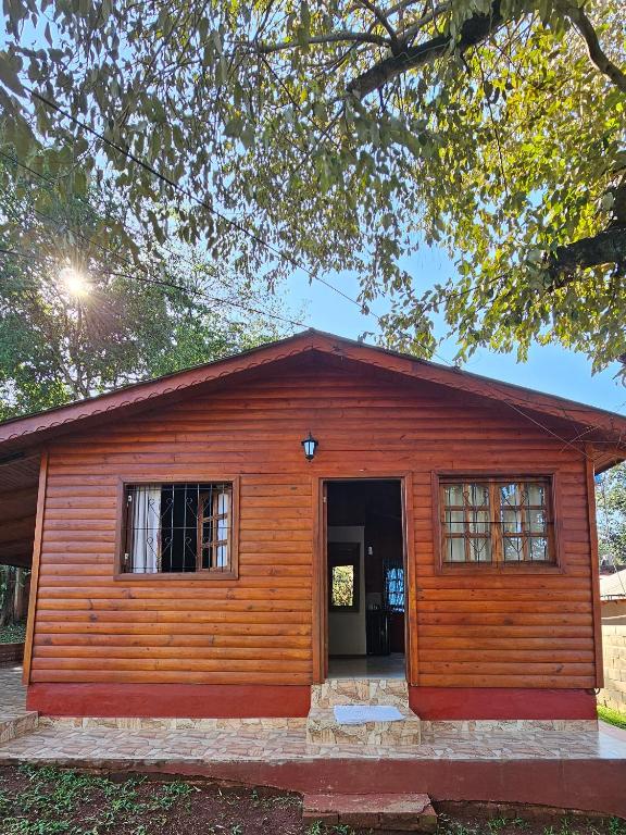 una piccola casa in legno con una grande porta di CABAÑAS PARAISO a Puerto Iguazú