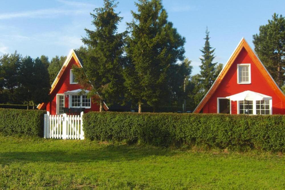 uma casa vermelha com uma cerca branca à frente. em Ferienhaus Chrissi, Rankwitz, Quilitz em Quilitz