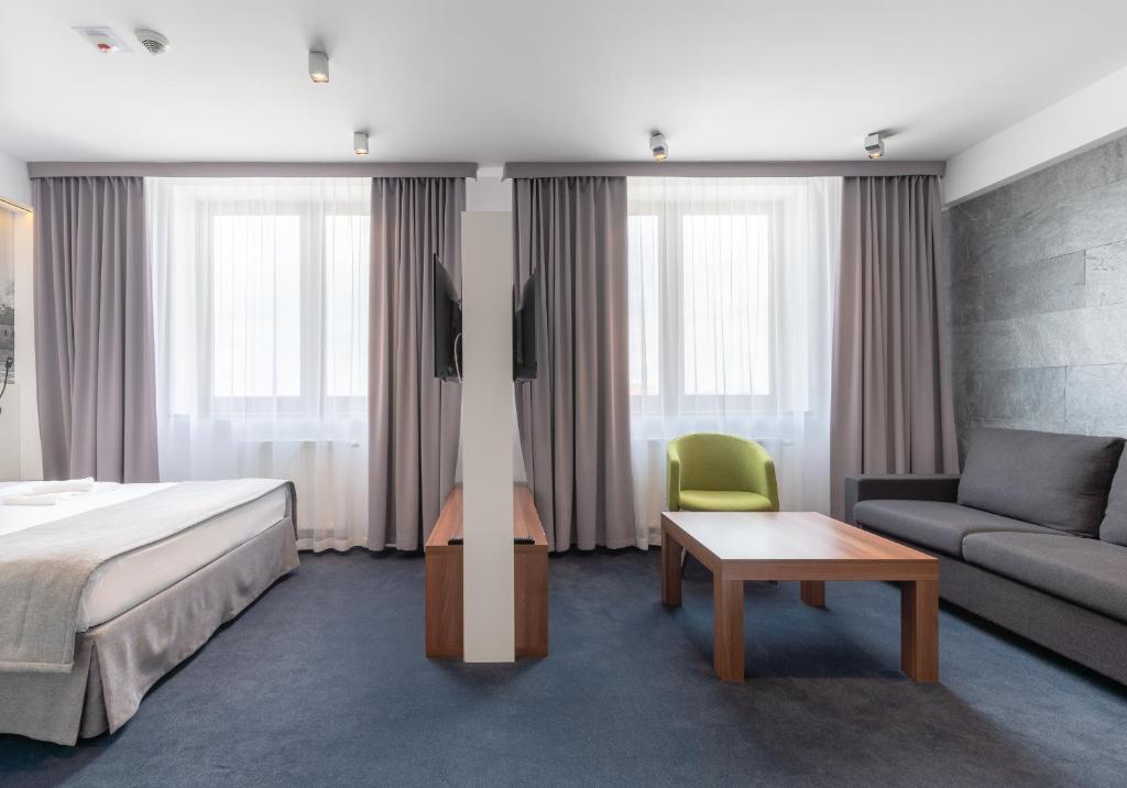 pokój hotelowy z łóżkiem i kanapą w obiekcie Terminal Hotel we Wrocławiu