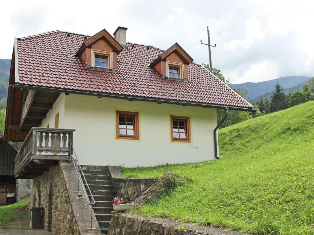 ein kleines weißes Haus auf einem Hügel mit Treppen in der Unterkunft Peaceful Cottage near Ski Area in Gm nd in Gmünd in Kärnten