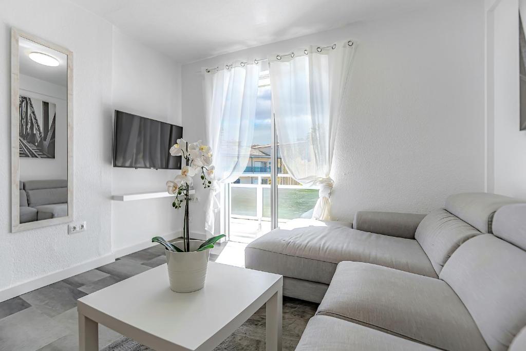a white living room with a couch and a table at Vistas al Teide y al mar 4 in Puerto de la Cruz