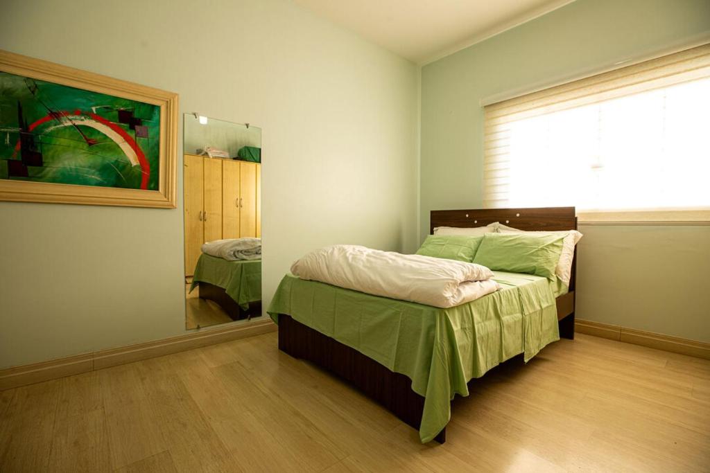 een slaapkamer met een bed en een grote spiegel bij Apto com otima localizacao e WiFi em Guarapuava PR in Guarapuava