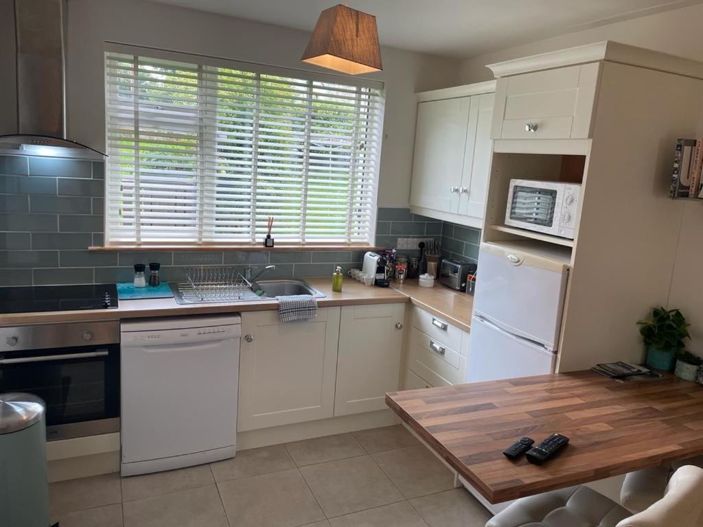a kitchen with white appliances and a wooden table at Beautiful one bedroom Apartment In Galway City in Galway