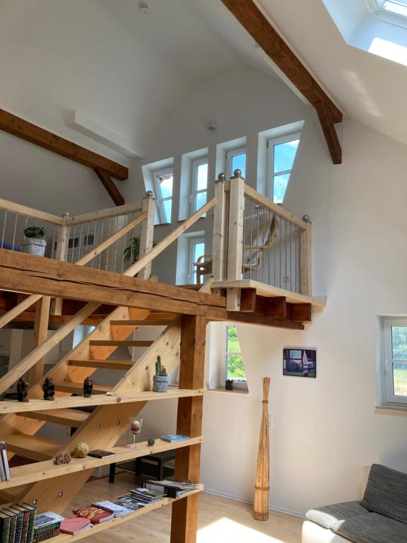 een loft met houten trap in een kamer bij Ferienwohnung Petrimühle 