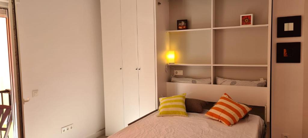 una camera con un letto con due cuscini sopra di Estudio Elizondo 2 a Benidorm