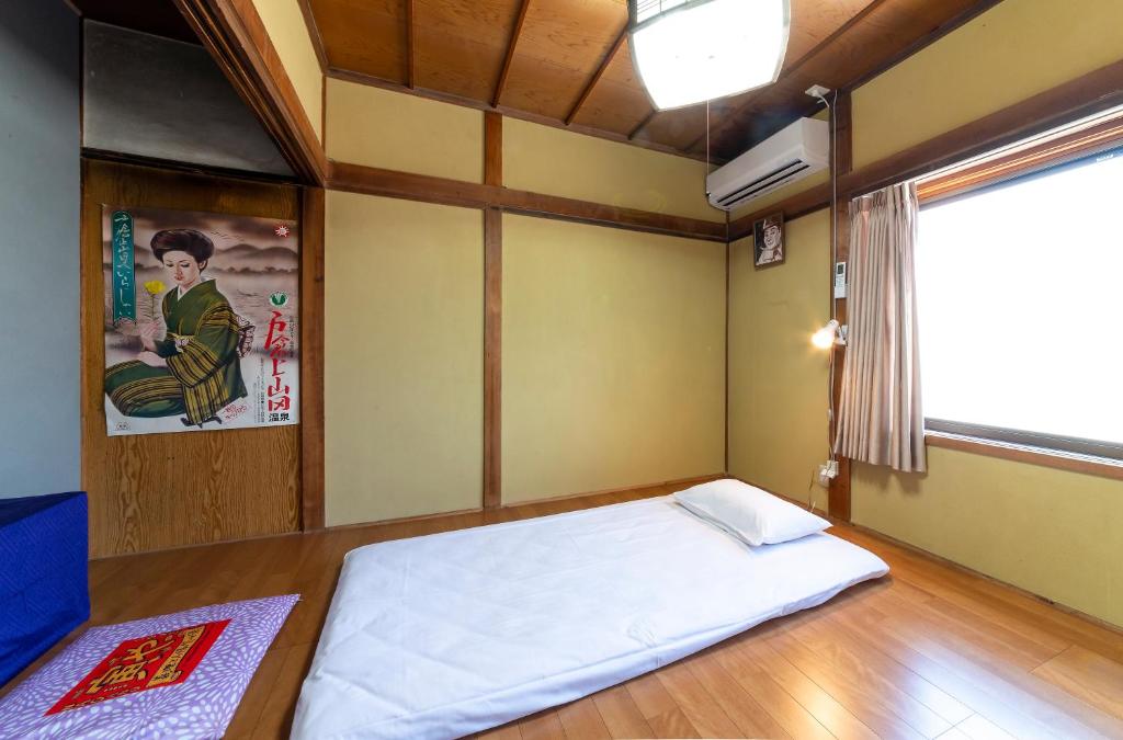 Postel nebo postele na pokoji v ubytování おせっかいゲストハウス 昭和の寅や