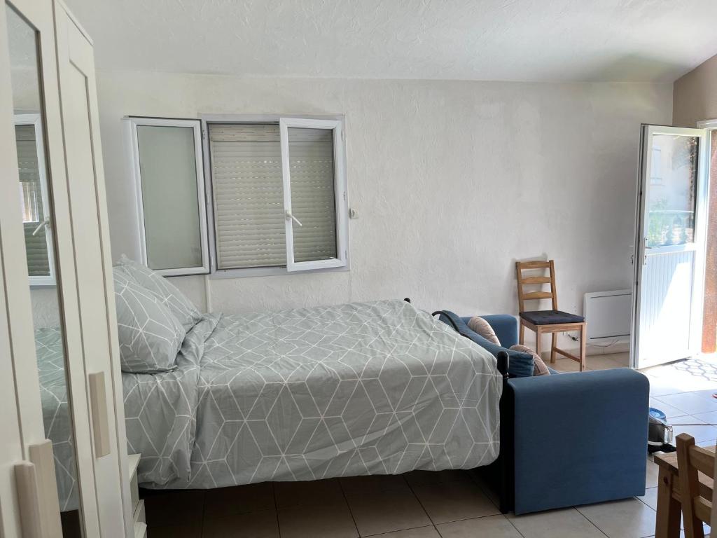 a bedroom with a bed and a blue couch at Un Studio dans un endroit tranquille in Roquefort-les-Pins