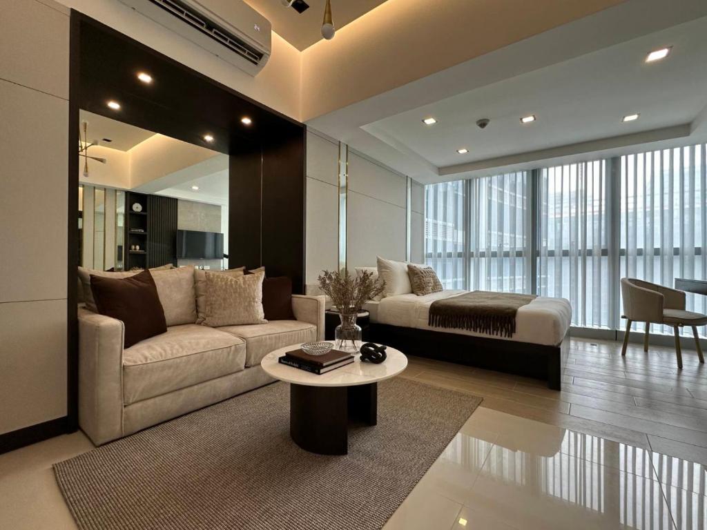 a living room with a couch and a bed at Uptown Parksuites BGC in Manila