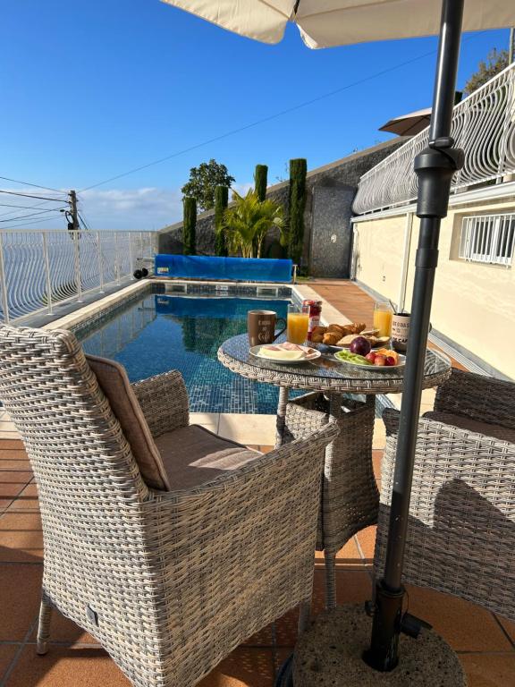 a patio with a table and chairs and a pool at Casa Del Mar in Ponta do Sol