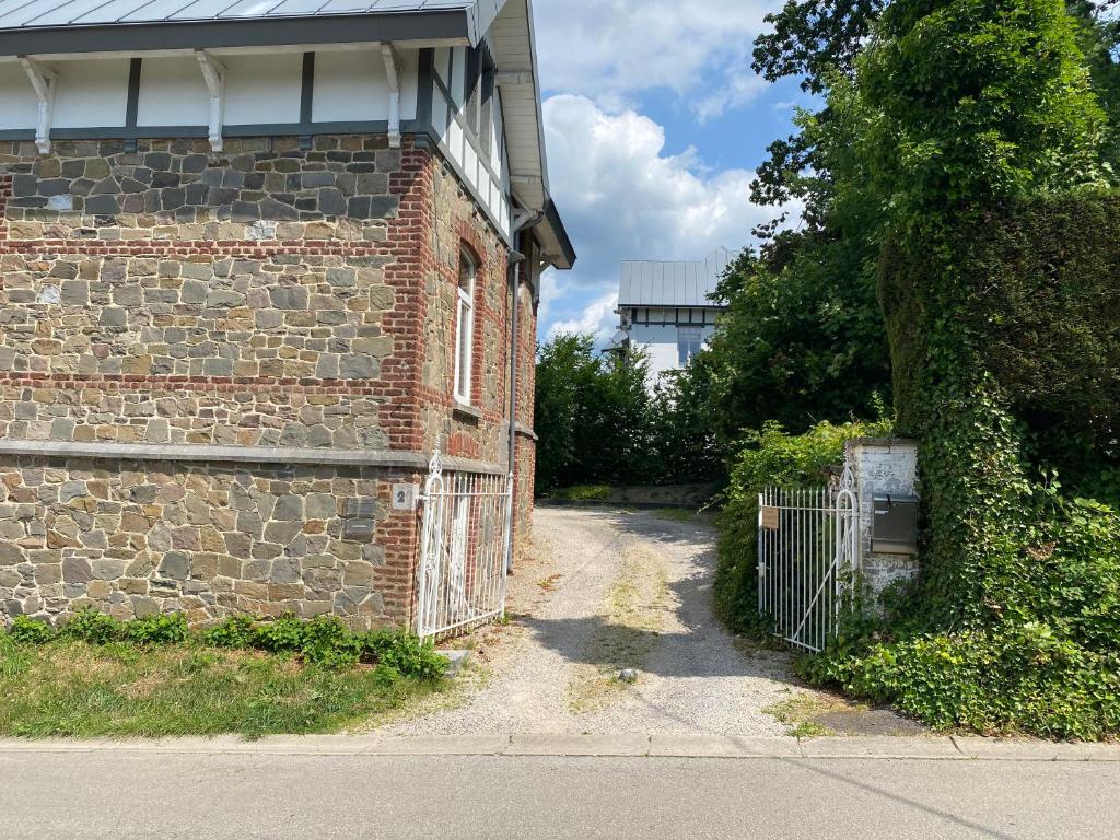 a brick building with a gate next to a street at Les Nids in Spa