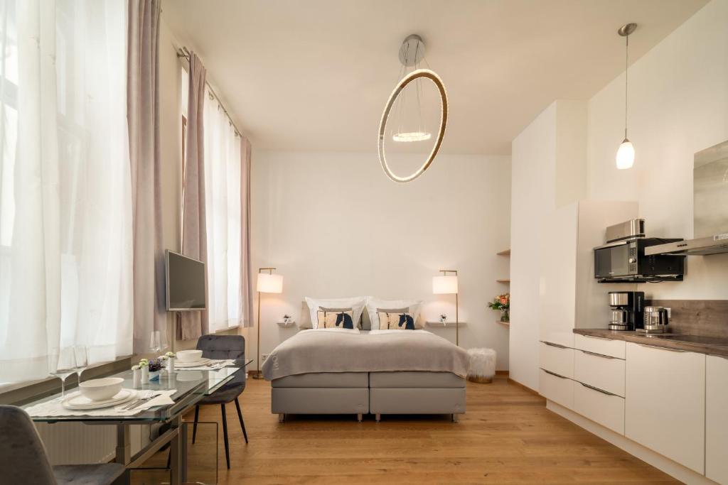 a white bedroom with a bed and a table at Comfort Apart Baden-Baden in Baden-Baden