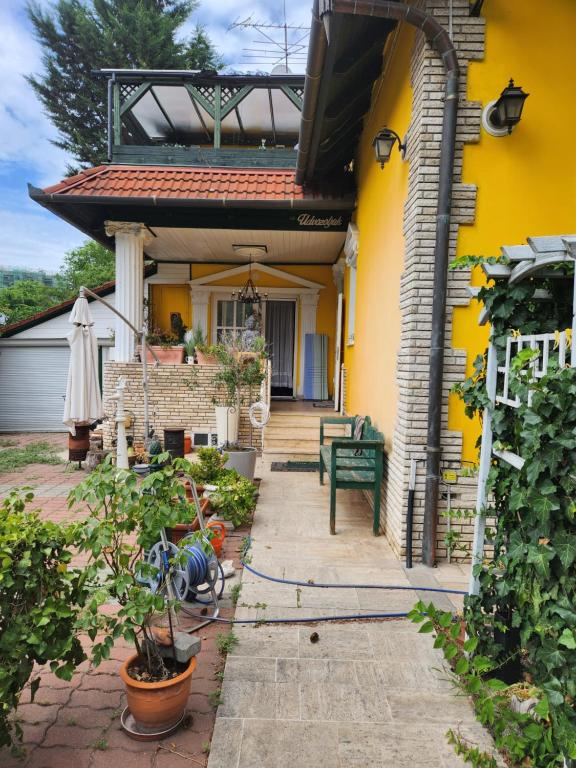 a yellow house with a porch with a patio at Marytilla in Budapest
