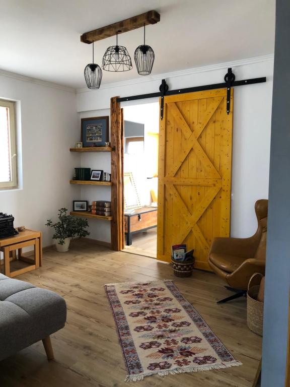 una sala de estar con una gran puerta de madera en Nantucket GuestHouse, en Vrbas