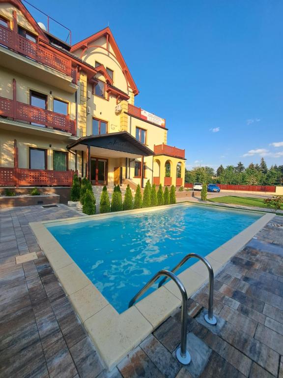 a swimming pool in front of a building at Lakeside Apartment in Palić