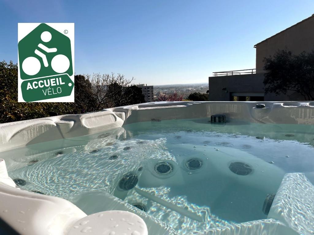 Whirlpool-Badewanne mit Recyclingzeichen im Hintergrund in der Unterkunft Sète, grande villa familiale avec Jacuzzi in Sète
