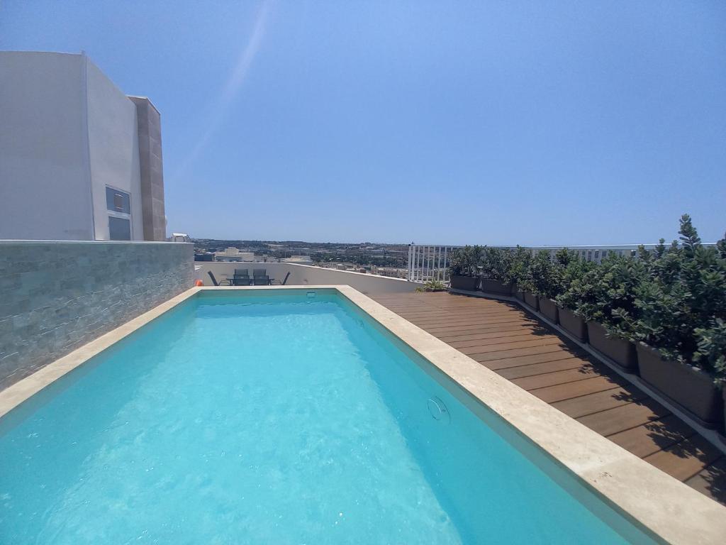 a swimming pool on the roof of a building at Luxury Penthouse with private pool in Tas-Samra