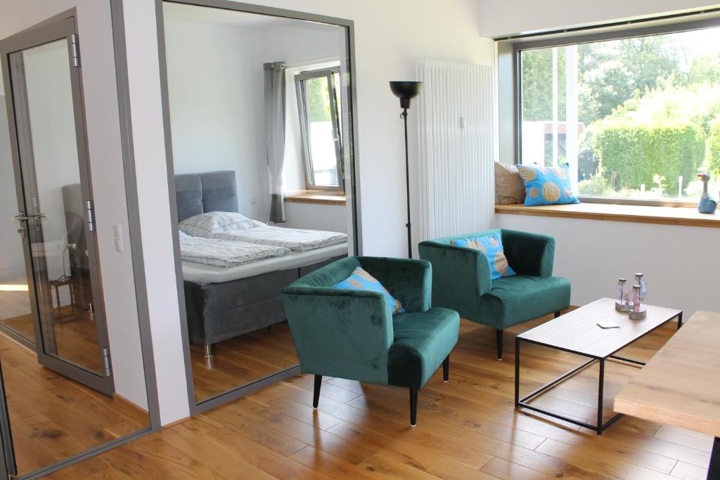 Habitación con espejo, 2 sillas y 1 cama en Ferienwohnung Haus Knäppen Size S en Oelde