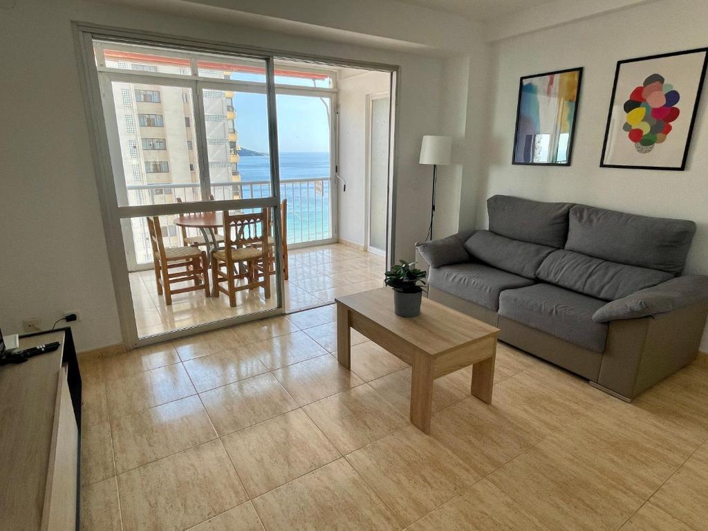 salon z kanapą i stołem w obiekcie Apartamento turístico Playmon Bacana Planta 13 w mieście Benidorm