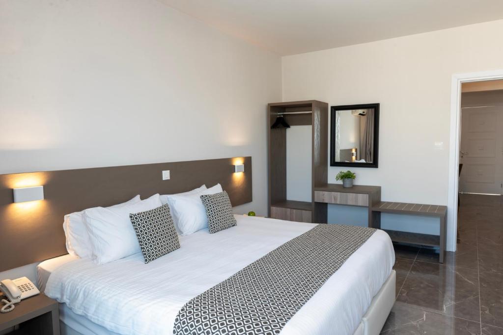 a hotel room with a large bed and a telephone at Blazer Residence in Larnaka