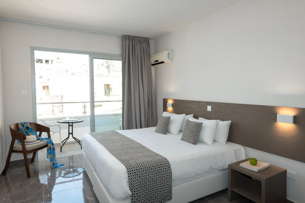 Habitación de hotel con cama y balcón en Blazer Residence, en Lárnaca