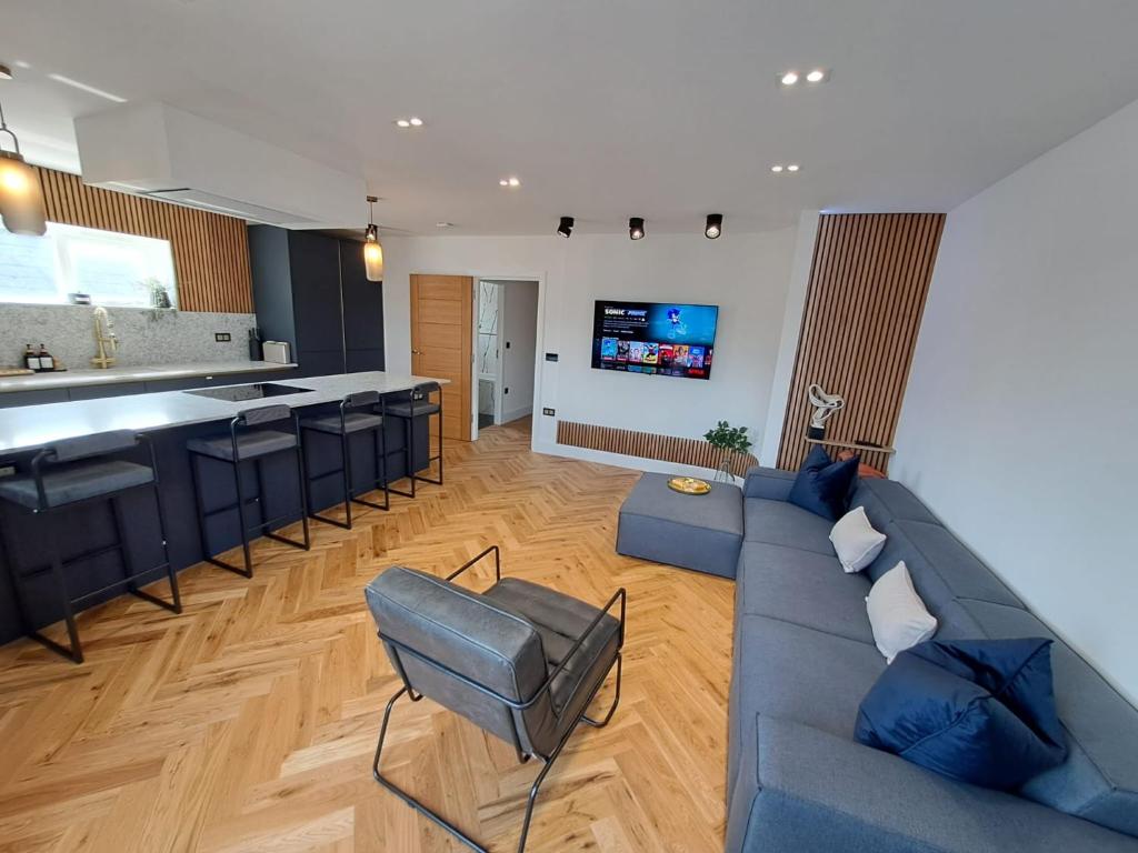a living room with a blue couch and a kitchen at Newly Renovated Flat with Parking space in Canterbury