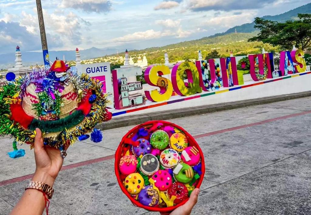 a person holding a plate of food in front of a sign at Casa Diversa in Esquipulas