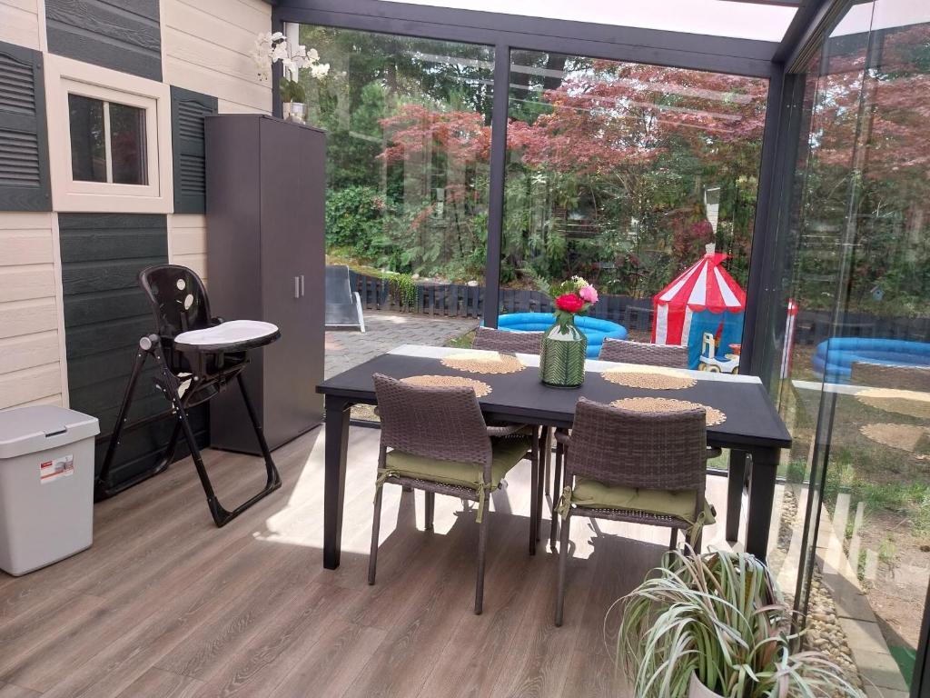 een patio met een tafel en stoelen en een speeltuin bij BPW 1105 - Bospark t Wolfsven in Mierlo