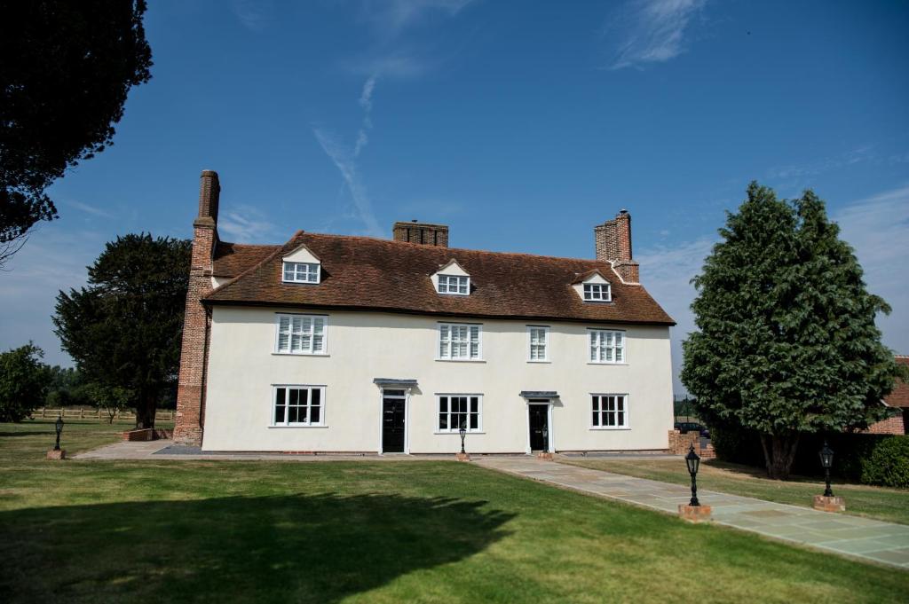een groot wit huis met twee schoorstenen bij Great Blunts House - Stock Brook Manor Golf Club in Stock