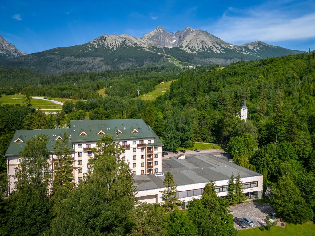 an aerial view of a building with mountains in the background at Hotel Slovan in Tatranská Lomnica