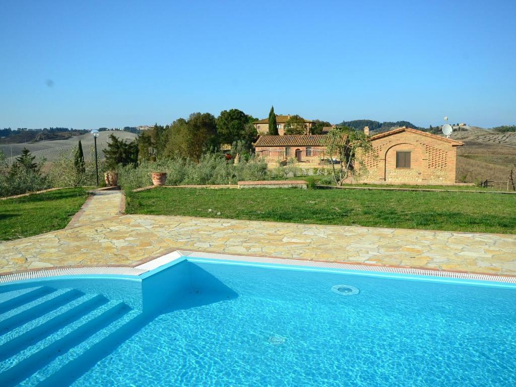 una grande piscina blu di fronte a una casa di Cosy agriturismo in Toscana with outdoor swimming pool a Peccioli