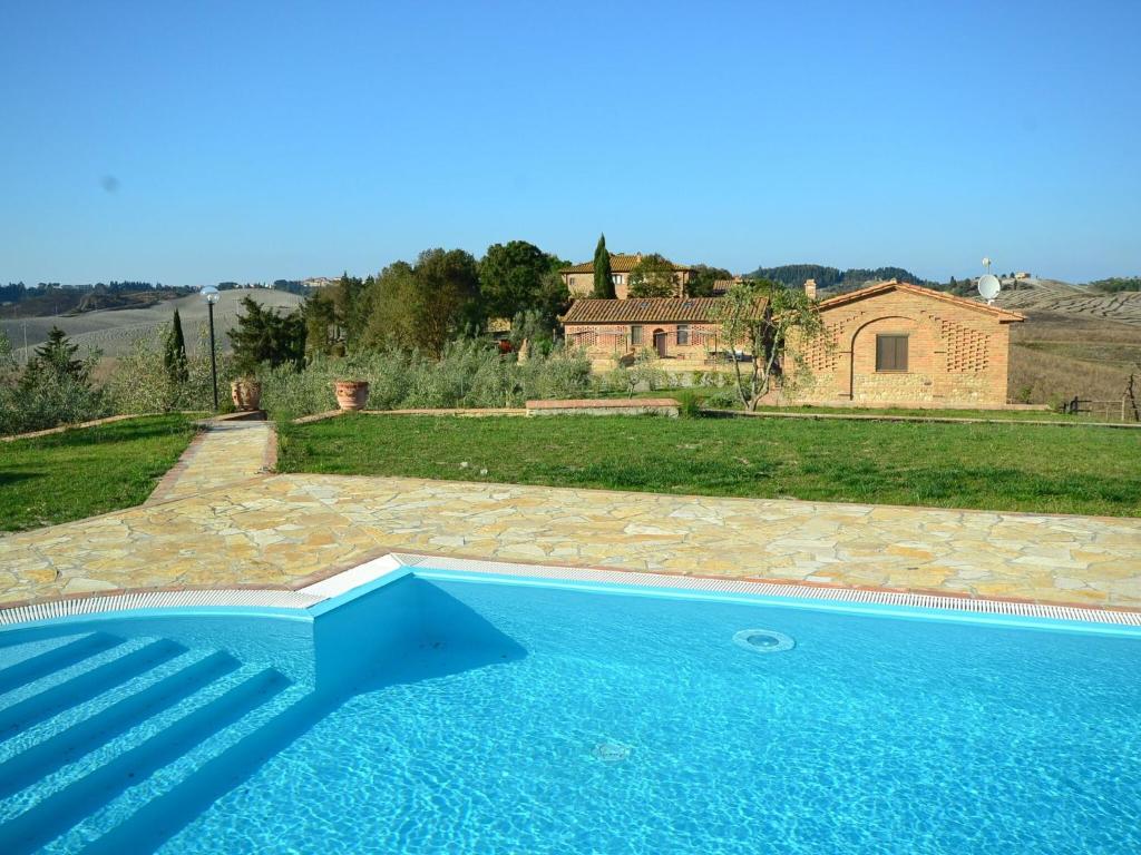 a large blue swimming pool in front of a house at Cosy agriturismo in Toscana with outdoor swimming pool in Peccioli
