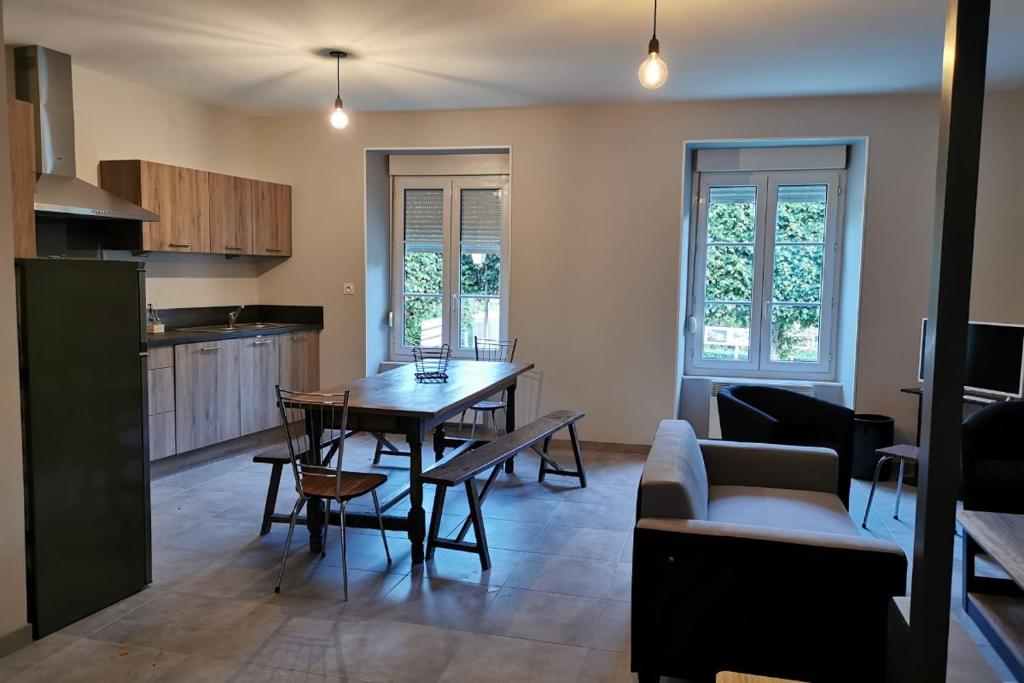 a kitchen and living room with a table and a couch at Gite Les Promenades in Bellême
