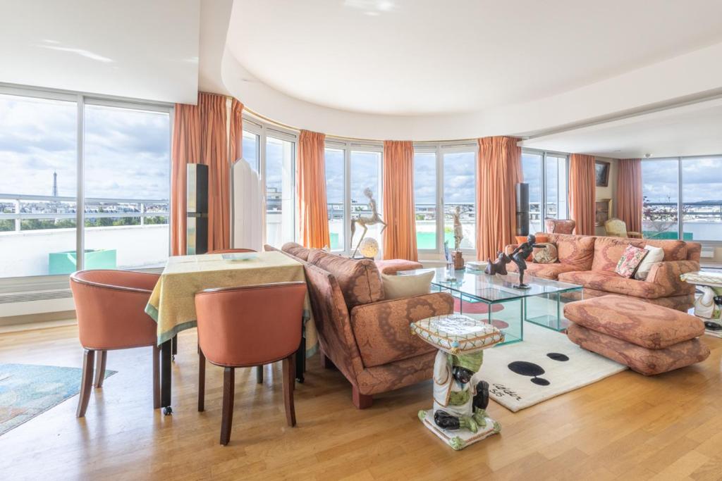 - un salon avec une table et des chaises dans l'établissement Luxury Apartment - Paris Eiffel Tower view, à Levallois-Perret