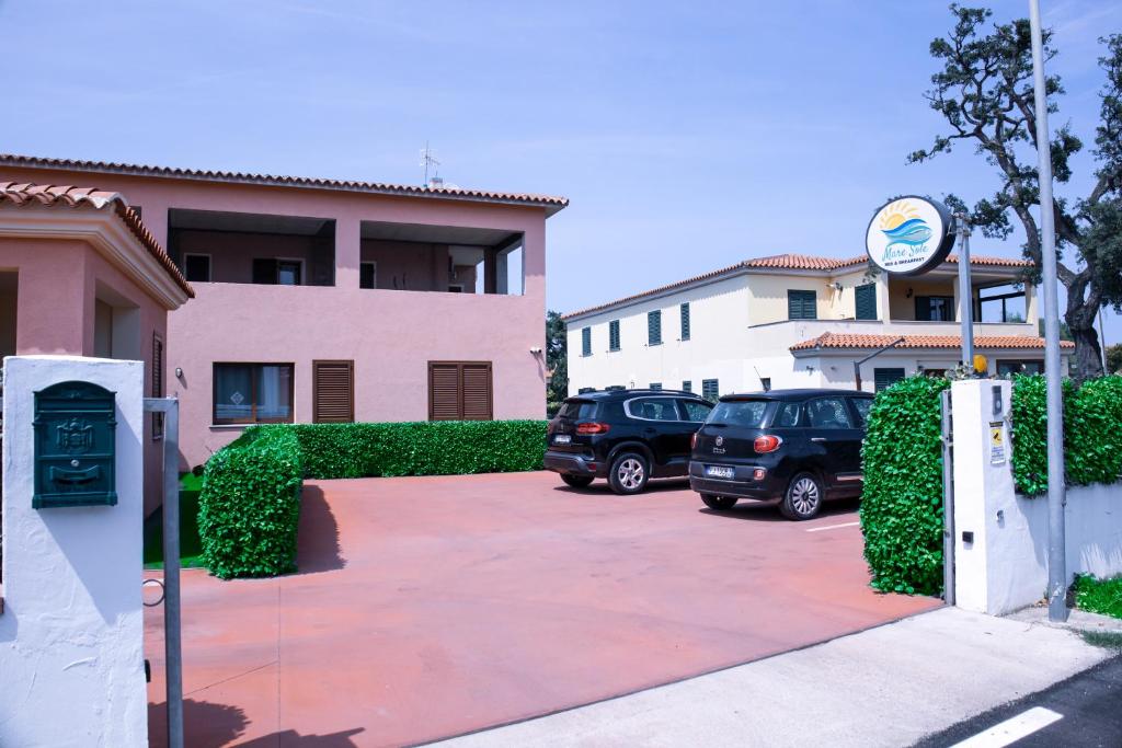 two cars parked in a parking lot in front of a building at Mare Sole in San Teodoro