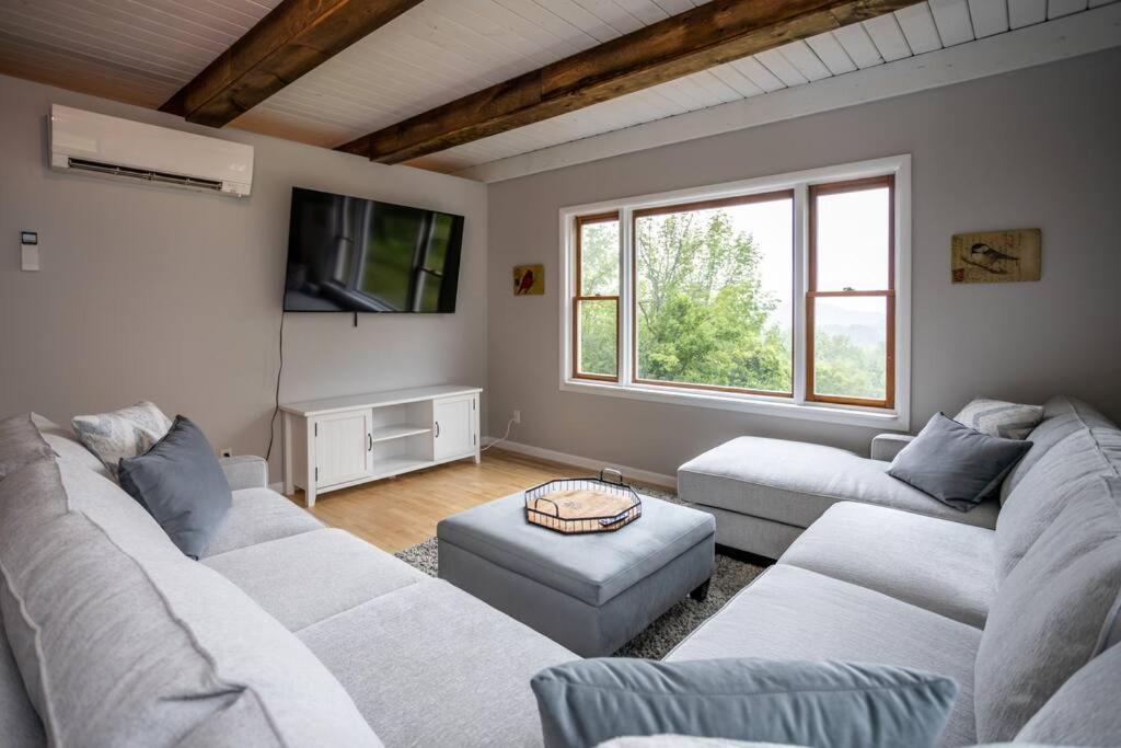 ein Wohnzimmer mit 2 weißen Sofas und einem TV in der Unterkunft Mountainview (Secluded Retreat) in Canandaigua