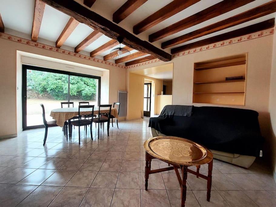 a living room with a table and a couch at Dépaysement à la campagne in Saint-Martin-de-Sanzay