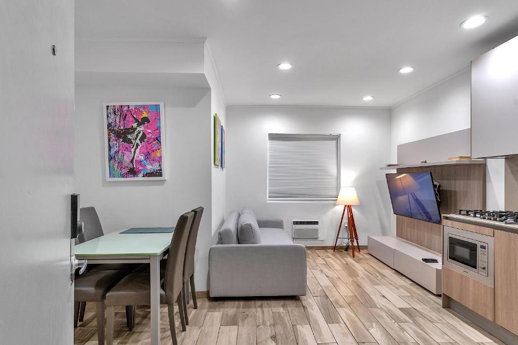 eine Küche und ein Wohnzimmer mit einem Tisch und einem Sofa in der Unterkunft Ocean Drive direct beach access South of Fifth Apartment in Miami Beach
