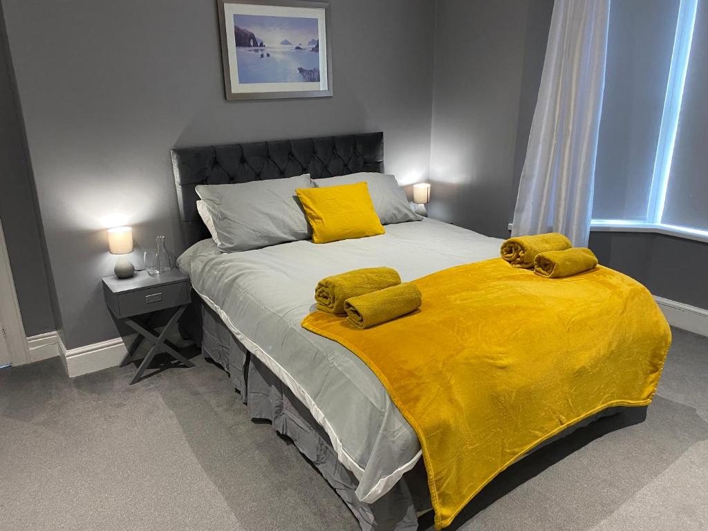 a bedroom with a bed with a yellow blanket on it at Seaside House-Next to the Beach, Sleeps 6 in South Shields