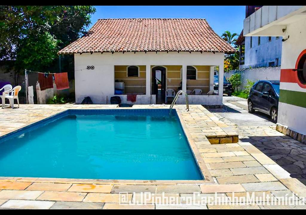 a swimming pool in front of a small house at CASA 7 qts sendo 4 suites, Piscina Churrasqueira 200 m praia Anjos in Arraial do Cabo