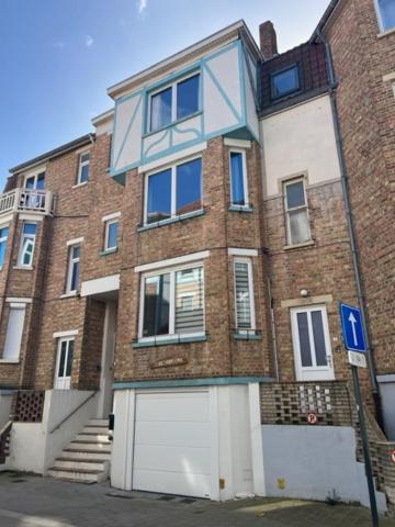 un grand bâtiment en briques avec un fond blanc et bleu dans l'établissement Belle époque à 5mn de la plage, à La Panne